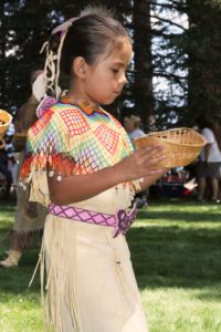 A young Washoe indian girl carries a basket in the Wa She Shu 'It Deh festival at Valhalla