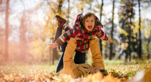 Little daughter enjoys time together with her mother in autumn nature