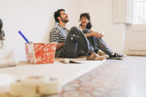 Couple is resting and having fun after hard work painting their apartment.